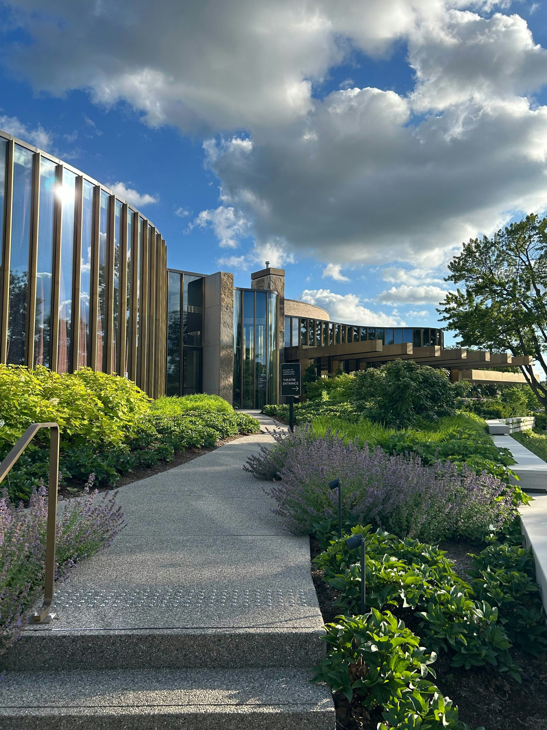 Modern building with curved architecture and lush green landscaping.